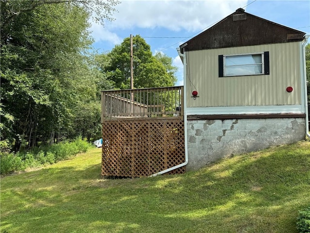 view of home's exterior with a deck and a lawn