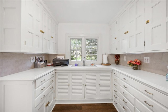 kitchen with decorative backsplash, sink, white cabinets, and dark wood-type flooring