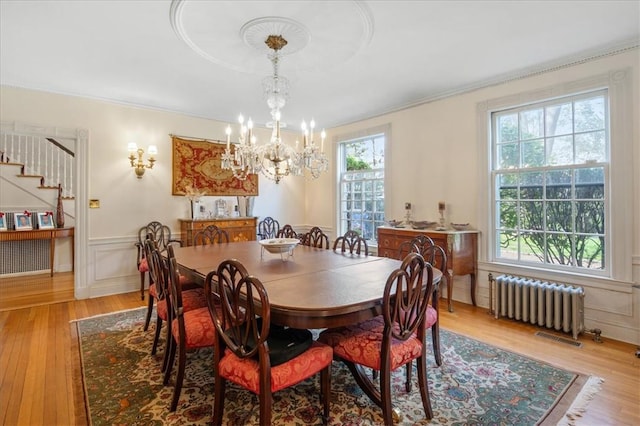 dining room with a wealth of natural light, radiator heating unit, and light hardwood / wood-style floors