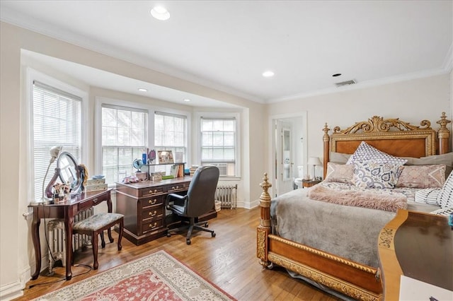 bedroom featuring light hardwood / wood-style flooring, radiator, and ornamental molding