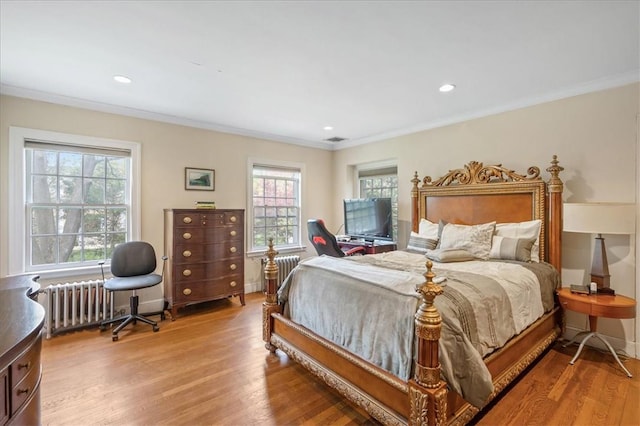 bedroom with radiator, hardwood / wood-style floors, and ornamental molding