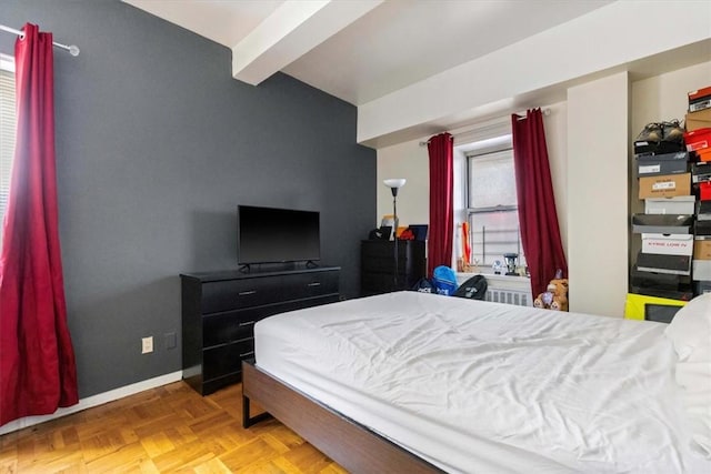 bedroom featuring beamed ceiling and light parquet flooring