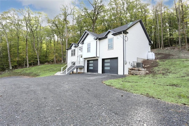 view of front of property with central AC unit and a garage