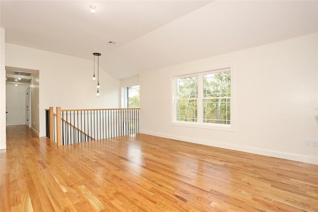 empty room with light wood-type flooring and lofted ceiling