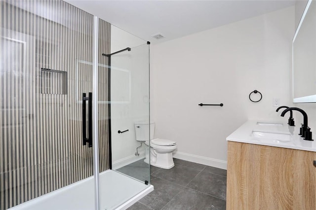 bathroom with tile patterned floors, vanity, toilet, and a shower with door