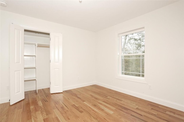 unfurnished bedroom with light wood-type flooring and a closet