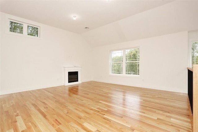 unfurnished living room featuring lofted ceiling and light wood-type flooring