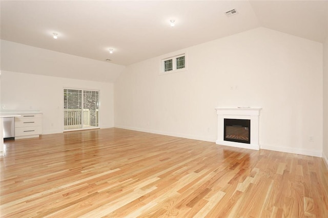 unfurnished living room with lofted ceiling and light wood-type flooring