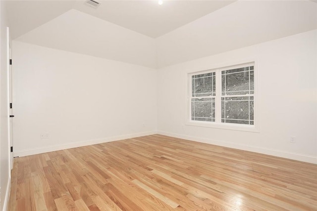 empty room with lofted ceiling and light hardwood / wood-style flooring