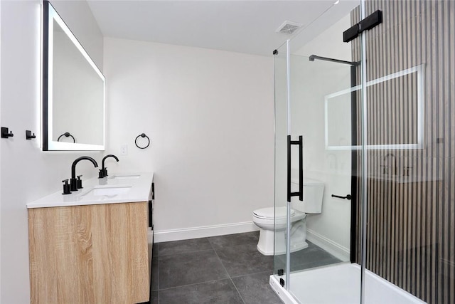 bathroom with tile patterned flooring, vanity, a shower with shower door, and toilet