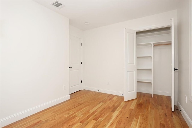 unfurnished bedroom with wood-type flooring and a closet