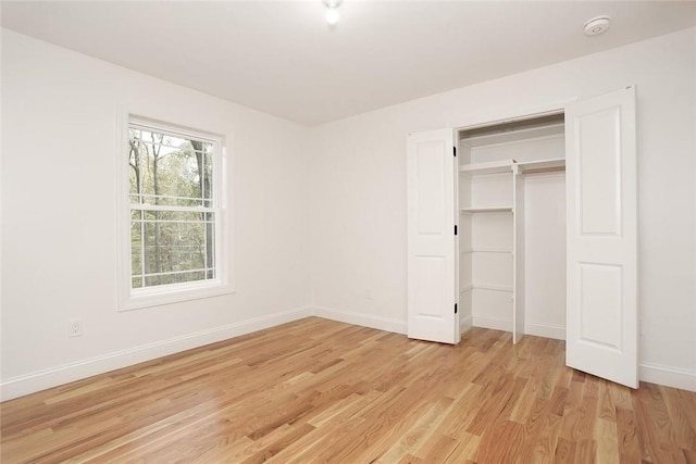 unfurnished bedroom with a closet and light wood-type flooring