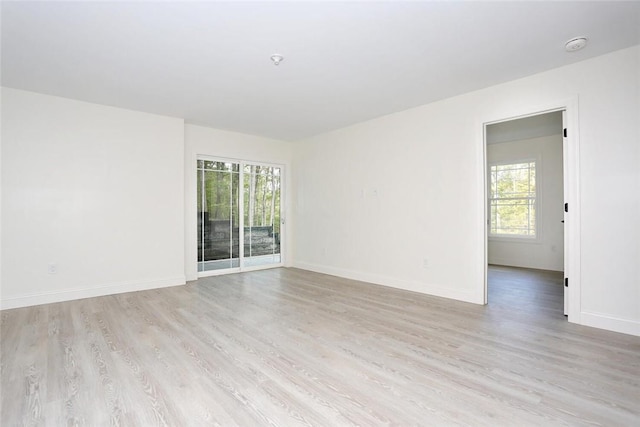 spare room featuring a wealth of natural light and light hardwood / wood-style flooring