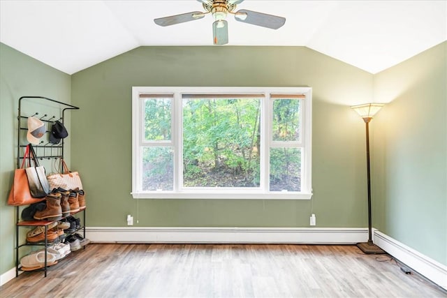 interior space with ceiling fan, light hardwood / wood-style floors, a baseboard heating unit, and vaulted ceiling