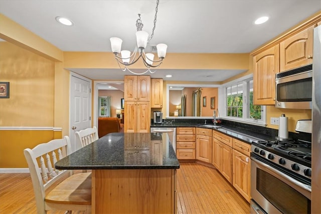 kitchen featuring pendant lighting, a center island, a notable chandelier, light hardwood / wood-style floors, and stainless steel appliances