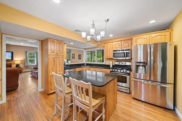 kitchen featuring sink, stainless steel appliances, a notable chandelier, and light hardwood / wood-style floors