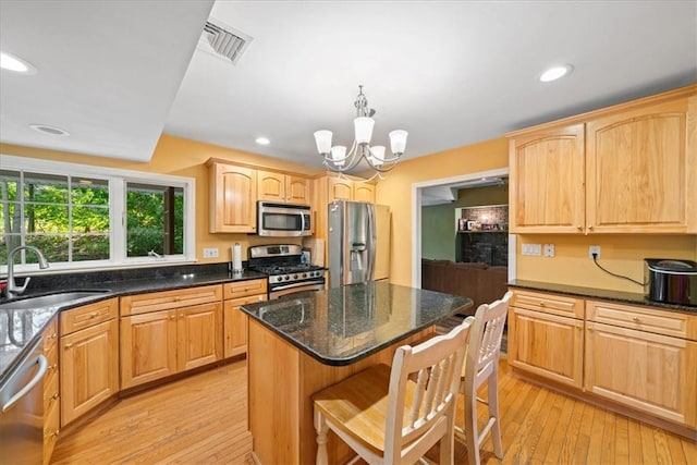 kitchen with sink, a center island, stainless steel appliances, light hardwood / wood-style flooring, and a notable chandelier