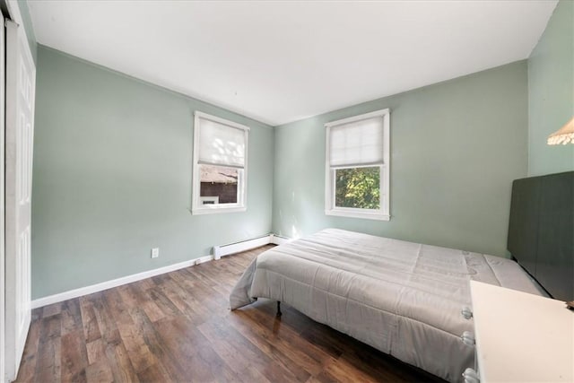 bedroom featuring dark wood-type flooring and a baseboard heating unit