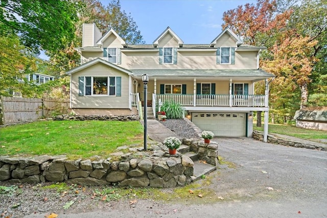 view of front of home with covered porch, a garage, and a front lawn