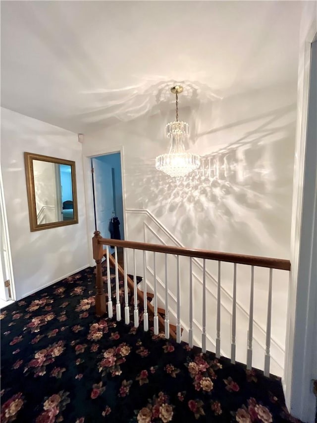 stairway featuring carpet floors and an inviting chandelier