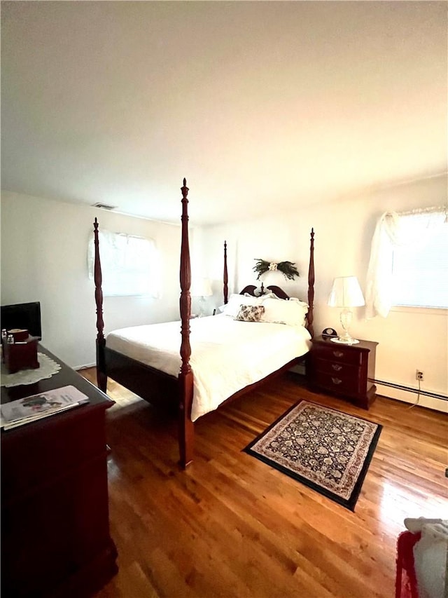 bedroom featuring a baseboard radiator and hardwood / wood-style flooring