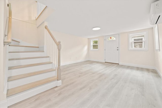 foyer featuring a wall mounted AC and light wood-type flooring