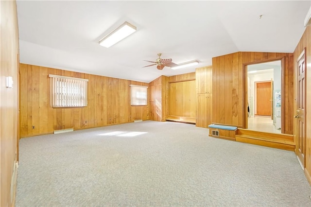 spare room with light colored carpet, vaulted ceiling, and ceiling fan