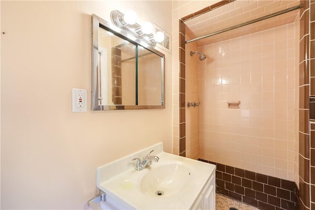 bathroom with tiled shower and vanity