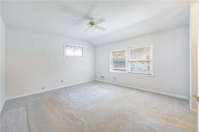 spare room with vaulted ceiling, ceiling fan, and light carpet