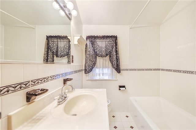 bathroom with sink, tile walls, tile patterned floors, and toilet