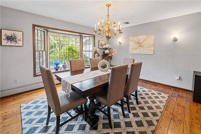 dining area featuring a chandelier, wood-type flooring, and a baseboard radiator