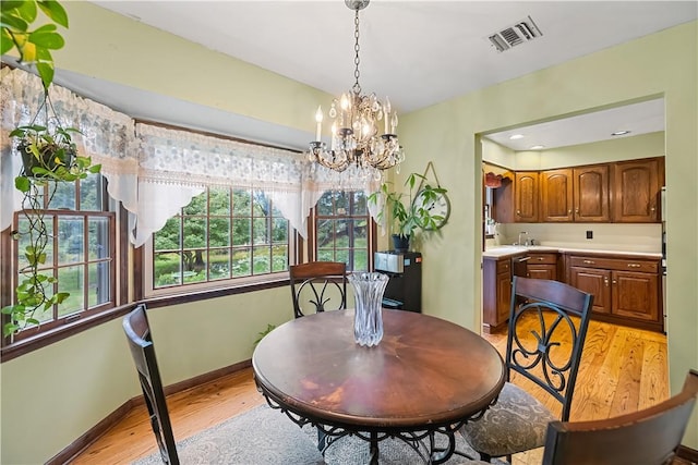 dining room featuring light hardwood / wood-style flooring, a chandelier, and sink