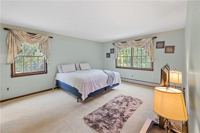 bedroom with light carpet, a baseboard radiator, and multiple windows