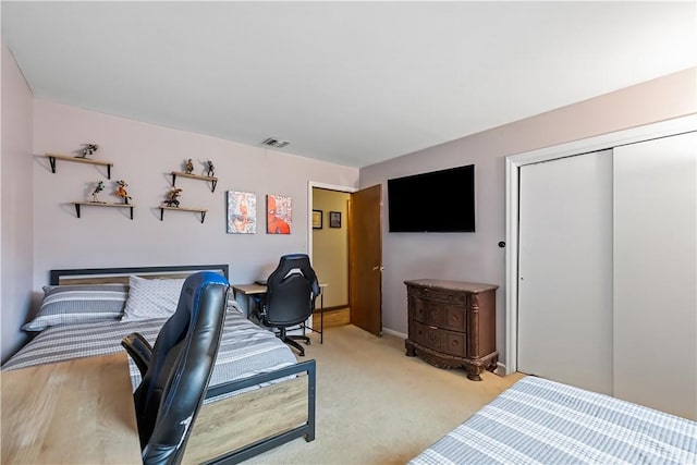 bedroom featuring light carpet and a closet