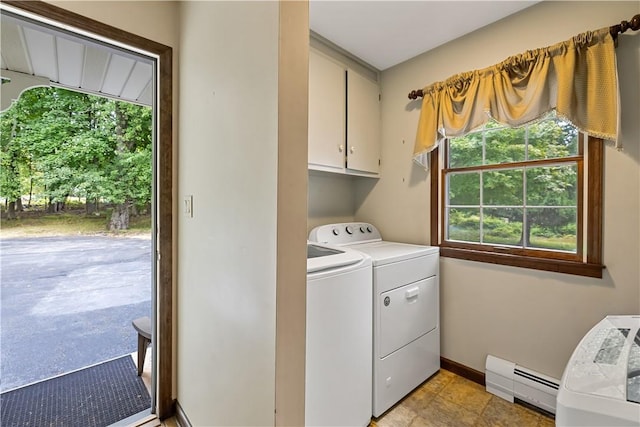 laundry room with washing machine and dryer, cabinets, and a baseboard heating unit