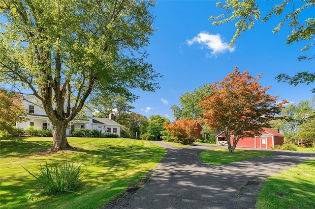 view of home's community with a lawn and an outbuilding