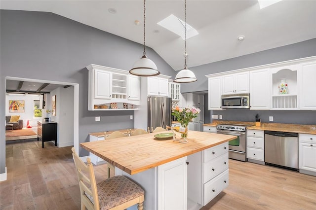 kitchen with butcher block counters, white cabinetry, pendant lighting, and appliances with stainless steel finishes