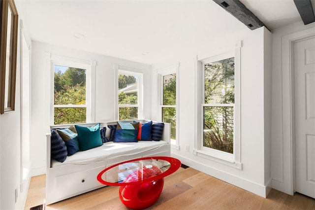 sunroom / solarium featuring beam ceiling