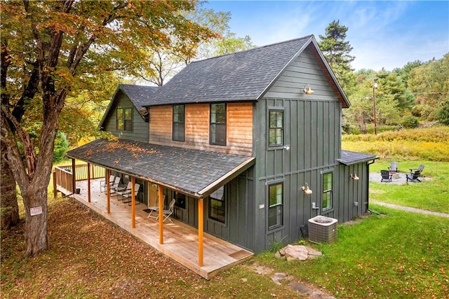 rear view of property with a yard and cooling unit