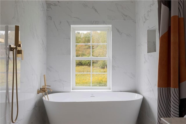 bathroom featuring a tub and tile walls