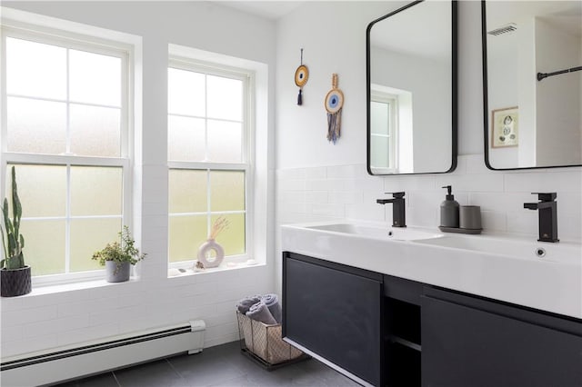 bathroom featuring tile patterned floors, a wealth of natural light, vanity, and a baseboard heating unit