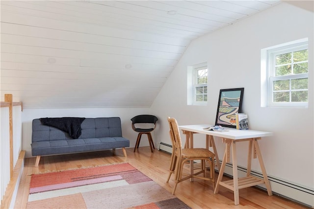 office space with a baseboard radiator, vaulted ceiling, and hardwood / wood-style flooring