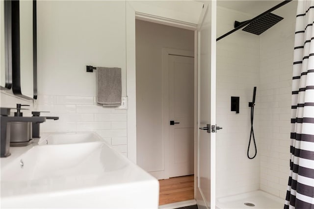 bathroom with hardwood / wood-style flooring, curtained shower, and sink