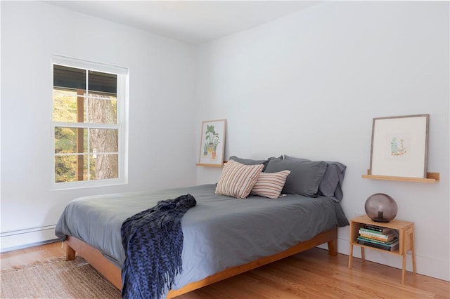 bedroom featuring wood-type flooring and baseboard heating