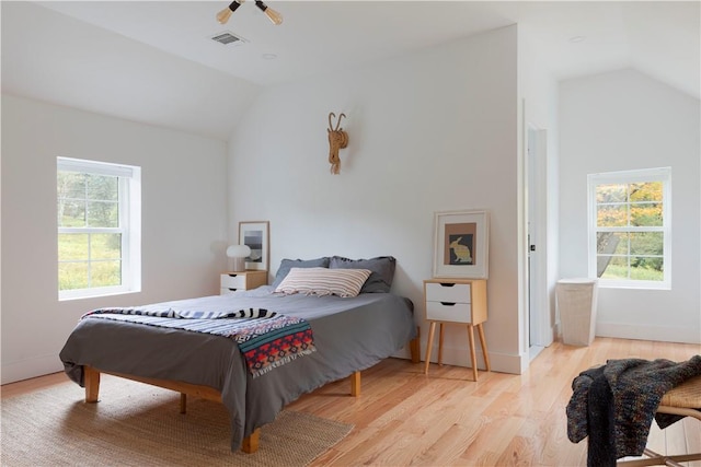 bedroom featuring light wood-type flooring and lofted ceiling