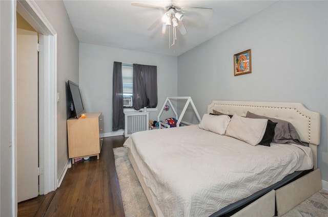 bedroom featuring dark hardwood / wood-style floors, ceiling fan, and radiator heating unit