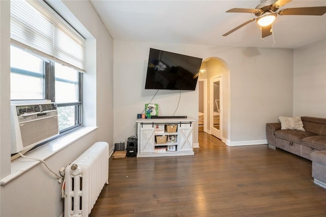 living room featuring ceiling fan, cooling unit, radiator heating unit, and dark wood-type flooring