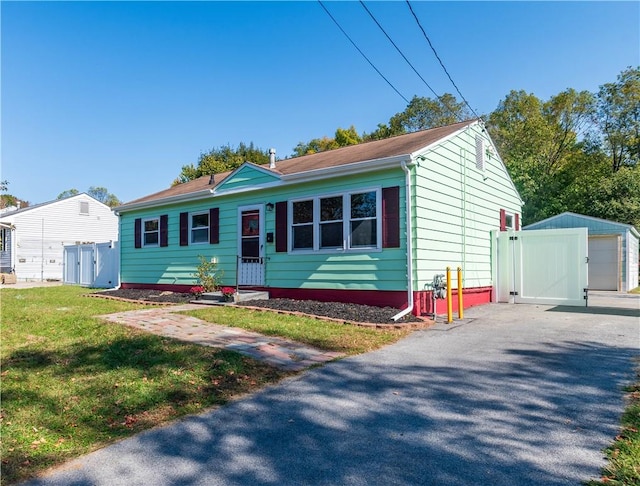 view of front of property with an outbuilding and a front lawn