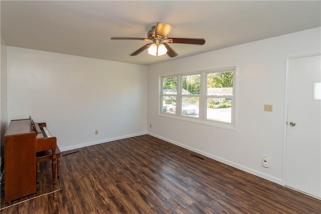 empty room with dark hardwood / wood-style flooring and ceiling fan