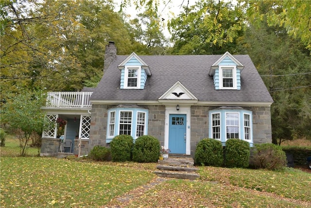 cape cod-style house with a front yard